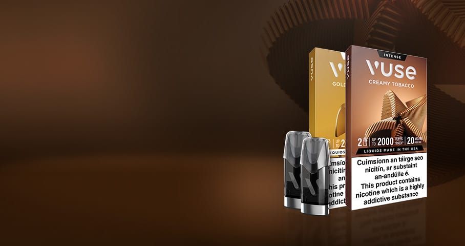 Two Vuse e-cigarette pod packs—one gold labeled Golden Tobacco, one brown labeled Creamy Tobacco—are displayed with two vape pods in front, set against a brown gradient background with abstract circular shapes.