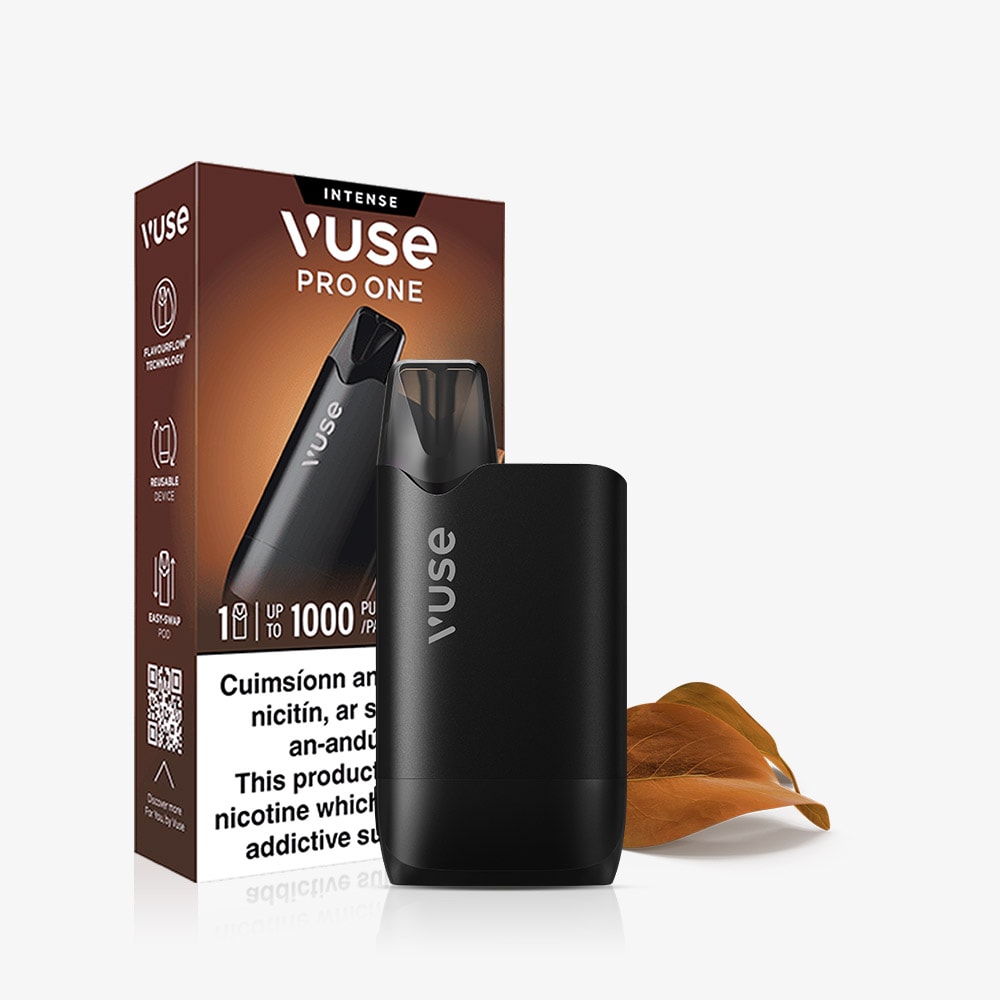 A black VUSE Pro One rechargeable vape device stands in front of its packaging, with a brown leaf beside it. The Vuse Pro One Box Creamy Tobacco features innovative FlavourFlow technology, with the packaging displaying product details and a nicotine warning.