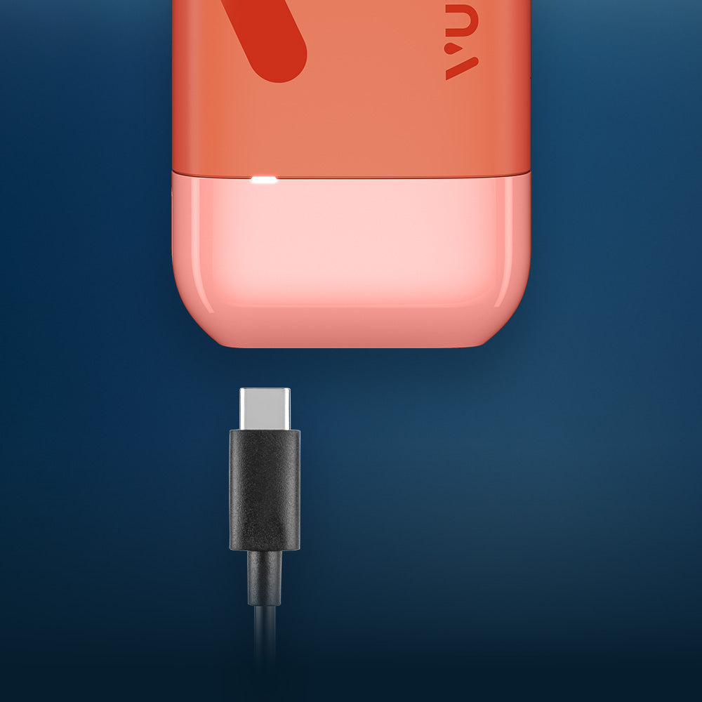 Vuse Ireland A black USB-C charging cable is positioned below a red and pink electronic device, ready to be plugged in, against a blue background.